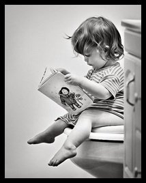 little girl reading in the bathroom